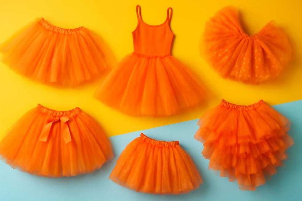 A colorful assortment of orange tutus in various styles against a lively backdrop, showcasing their charm.