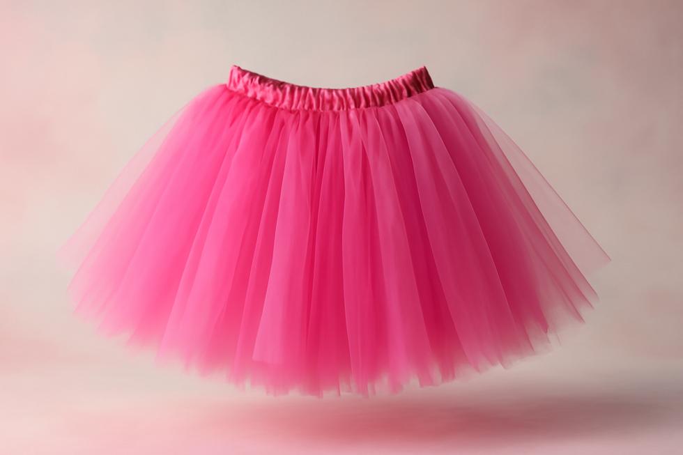 A beautiful pink tutu skirt displayed against a soft background, highlighting its fluffy design and playful character.