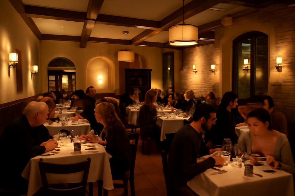 A beautifully decorated interior of Tutti Fresco, filled with diners and warm lighting that enhances the dining experience.